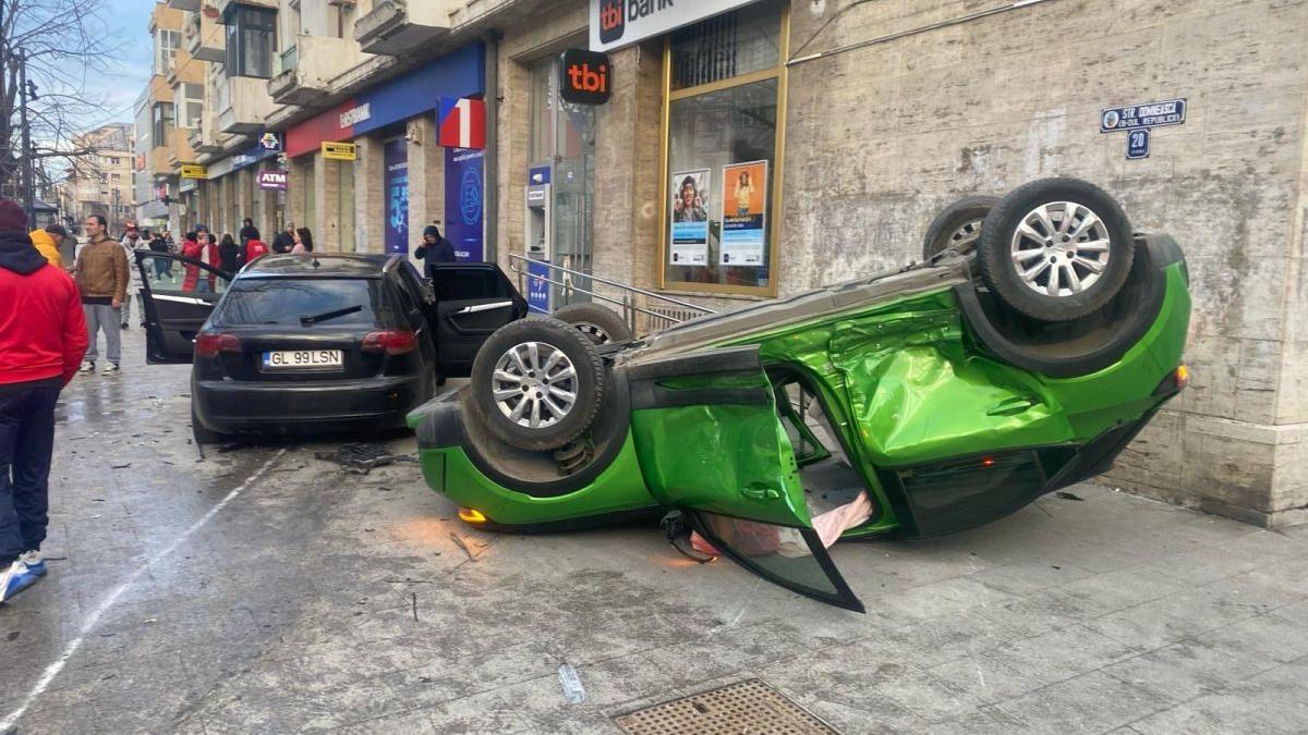 Două mașini au ajuns pe trotuar în centrul Galațiului. Una s-a răsturnat la intrarea într-o bancă