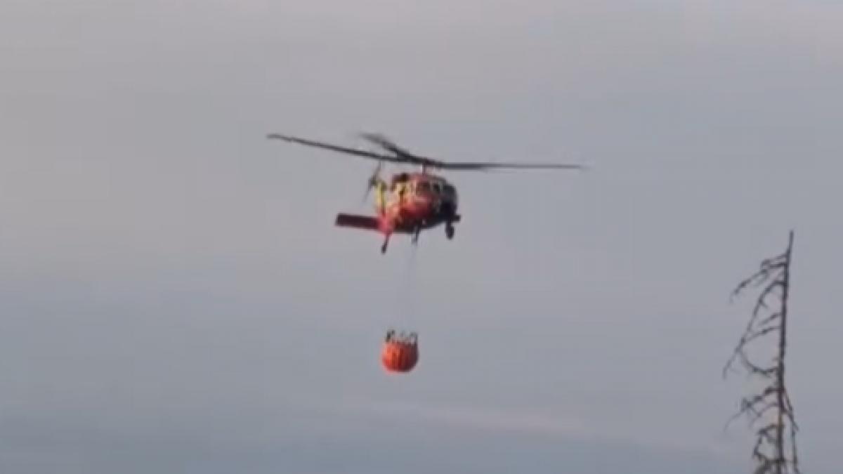 Incendiu masiv de vegetație într-o zonă greu accesibilă din Băile Olănești. Un elicopter intervine în sprijinul pompierilor