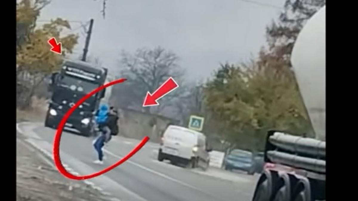 Poliția Română publică o imagine cu o mamă cu copilul în brațe, trecând grăbită printre două TIR-uri