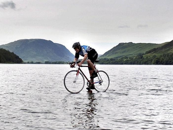 Sfidează gravitaţia! Un tânăr merge cu bicicleta pe un lac adânc de 23 de metri!