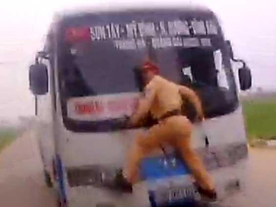 Cine-i mai nebun? Poliţistul agăţat de ştergătoare sau şoferul autobuzului (VIDEO)