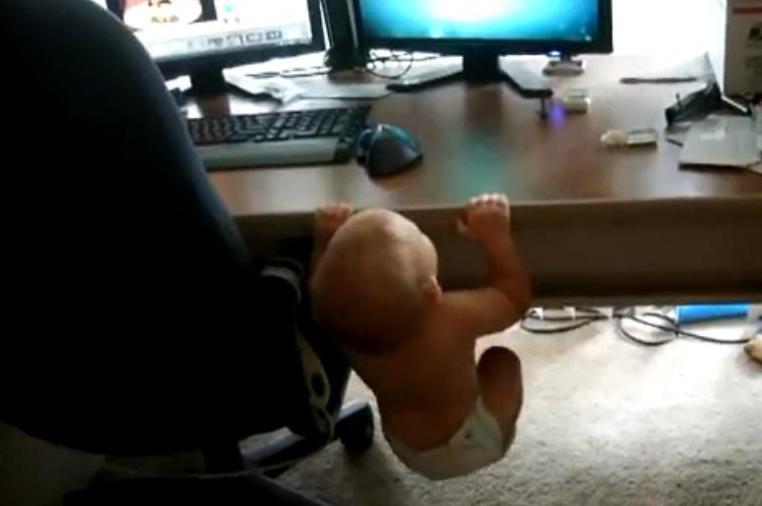 Cu pamperşii la purtător, un bebeluş de câteva luni face tracţiuni pe marginea biroului (VIDEO)