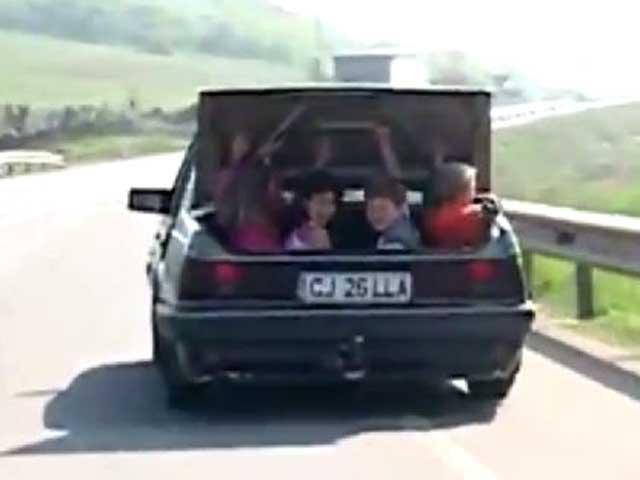 Distracţie românească: pe şosea cu copiii în portbagajul maşinii! (VIDEO)