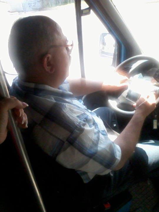 (FOTO) Şoferul unui microbuz plin cu oameni conduce cu coatele şi urmăreşte filme la volan!