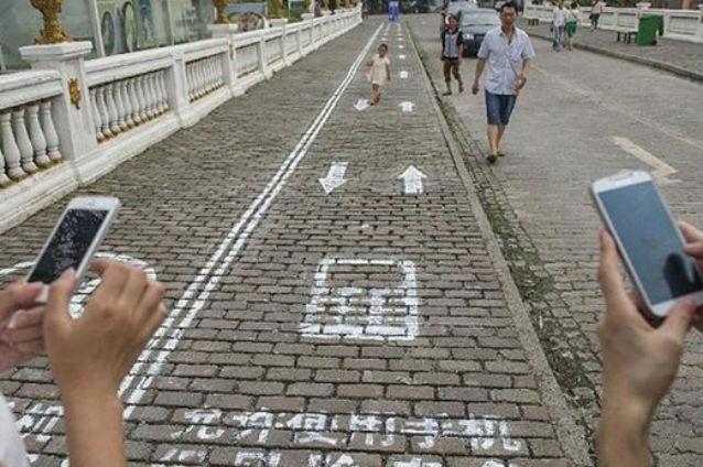 Bandă specială pe un trotuar din China pentru pietonii dependenţi de telefonul mobil