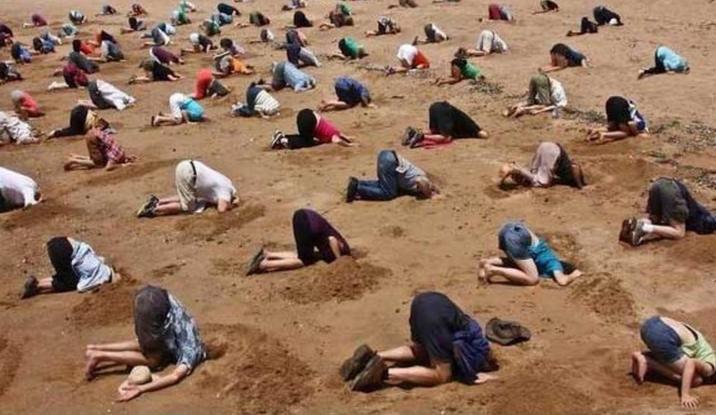 PROTEST BIZAR în Australia. Zeci de militanţi ecologişti şi-au îngropat capul în nisip, pe o plajă din Sydney 
