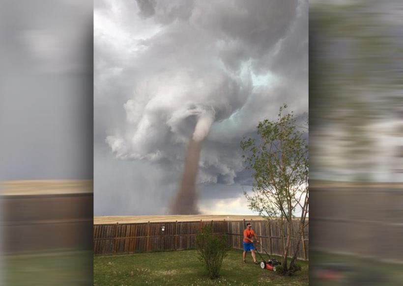 O fotografie în care un canadian tunde iarba in timp ce o tornadă se află în spatele lui, face vâlvă pe internet