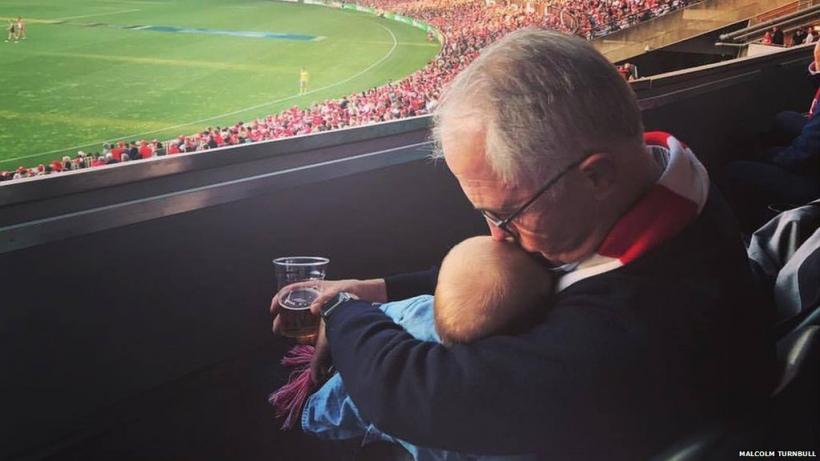 O fotografie a premierului cu un bebeluş într-o mână şi cu o bere în cealaltă provoacă reacţii împărţite în Australia