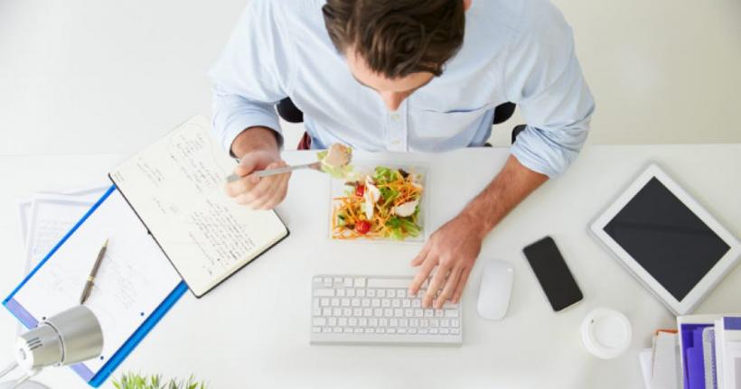 Românii sunt în topul angajaţilor din Europa care preferă să consume prânzul pe tastatura computerului