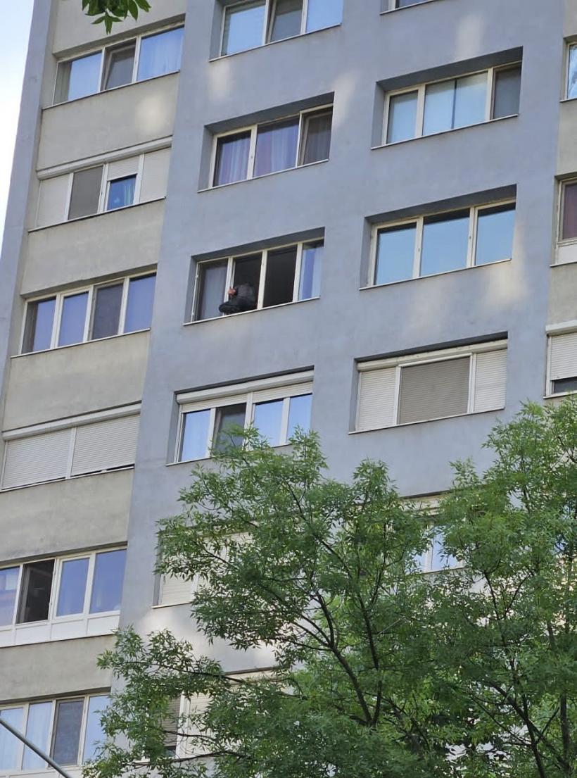 Militarul care amenință că se aruncă de la etajul 7 nu a renunțat nici după 24 de ore. Bărbatul încă stă pe pervazul geamului