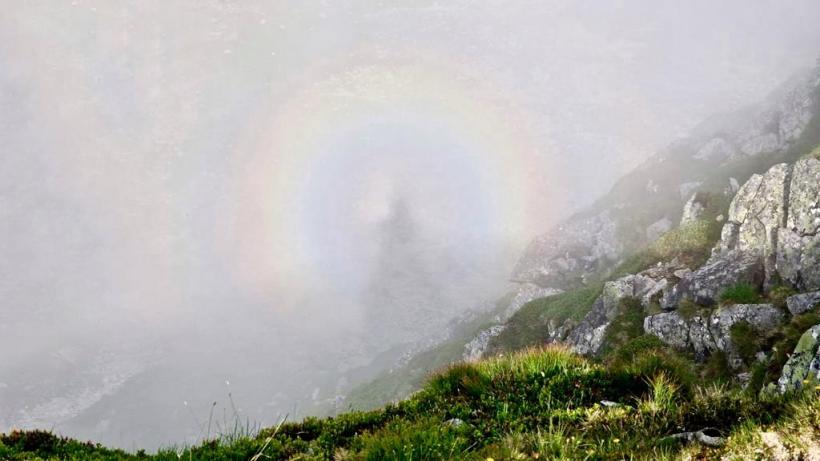 Efectul Gloria, surprins de un preot în Parâng: Dumnezeu pune o pauză și îți îmbracă umbra cu un curcubeu 18849693