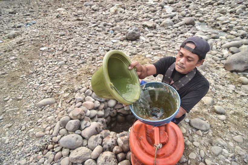 Secetă extremă: oamenii sapă în albia unui râu secat 18853805