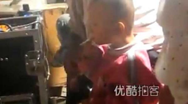 china un baietel de trei ani trage cu nesat din tigara fara ca nimeni sa l impiedice video