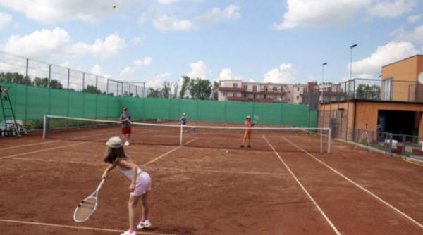 copiii unor milionari americani se antreneaza la tenis la o baza construita pe terenul unui fost ias parasit