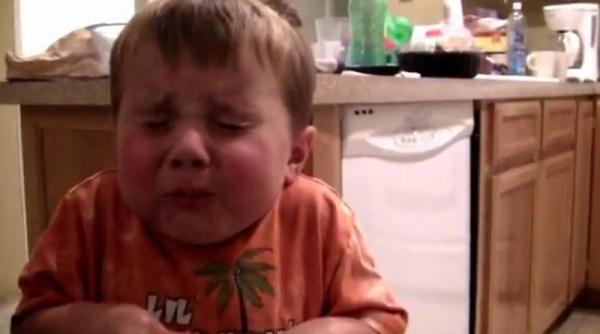 video amuzant reactia unui copil in timp ce mananca o bomboana foare amara