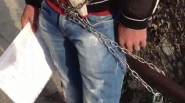 un tanar protesteaza legat cu lanturi de gardul unei clinici private din pitesti barbatul acuza un medic ca i a omorat copilul la nastere