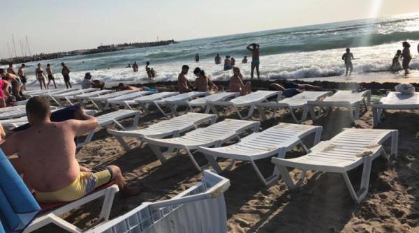 bataie de joc pe plaja din eforie nord daca ar putea pune sezlongul in apa ar face si asta