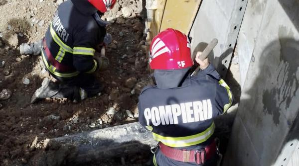 interventie contracronometru a pompierilor pentru salvarea unui barbat de sub un mal de pamant se sapa in jurul lui cu lopeti si uneori cu mainile goale pentru a nu l rani