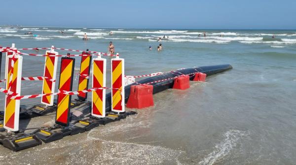 Țeavă deversând ape pluviale direct în mare, lângă turiști, la Năvodari