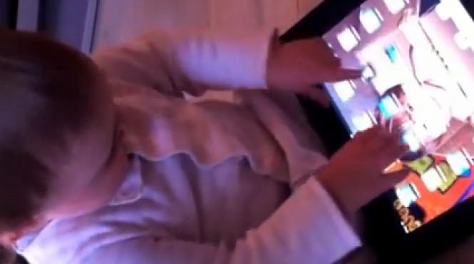 fetita de un an contrariata ca revistele colorate nu functioneaza la fel ca ipad ul tatalui sau video