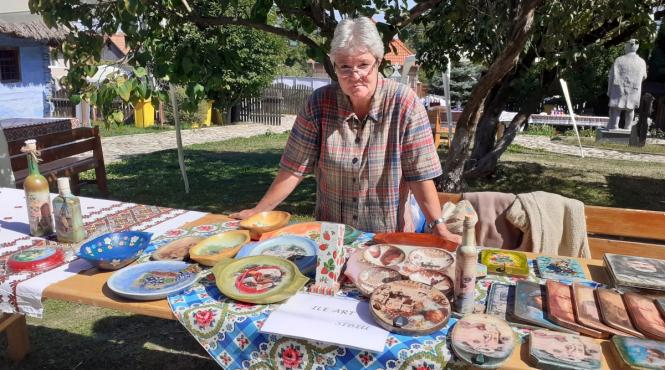 profa care picteaza pe lemnele lingurarilor